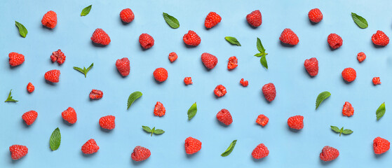 Many fresh raspberries and mint on blue background