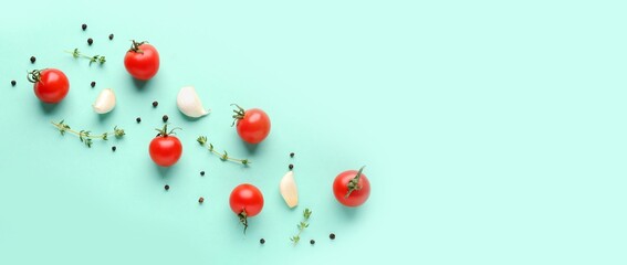 Ripe cherry tomatoes, thyme and spices on turquoise background with space for text, top view