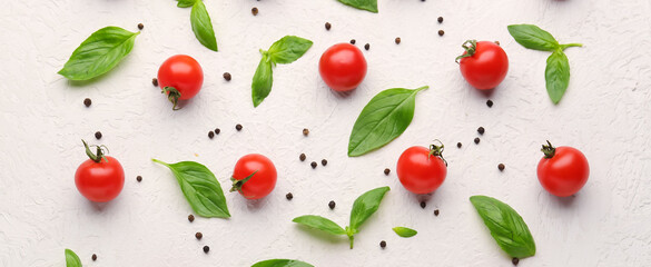 Composition with ripe cherry tomatoes, basil leaves and peppercorn on light background