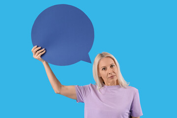 Mature woman with blank speech bubble on blue background