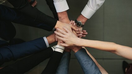 Diverse group of professionals joining hands in a circle symbolizing unity and teamwork