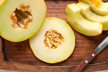 Wooden board with pieces of sweet melon, closeup