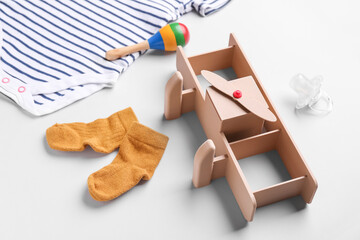 Composition with baby clothes, toys and pacifier on grey background