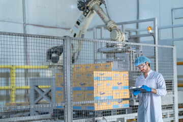 A quality control specialist in a modern factory inspects production processes while recording data...
