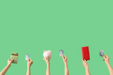 Women with credit cards, calculator, piggy bank and wallet on green background