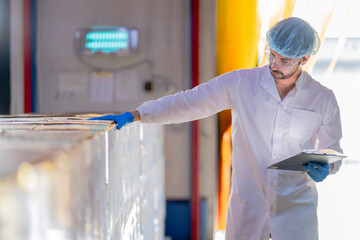 A meticulous male scientist in a sterile environment meticulously documents quality control data on...