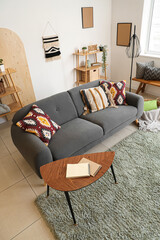 Interior of living room with black sofa, coffee table and cushions