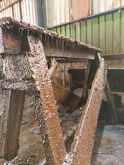 Corroded steel structure coated with thick layers of oil and dirt, captured in an old warehouse...