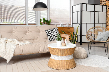 Interior of beautiful living room with comfortable sofa, coffee table and armchair