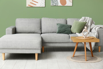 Interior of stylish living room with sofa, coffee table, plaid and pillows