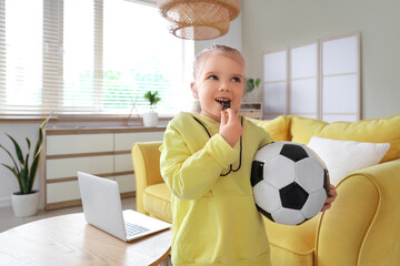 Cute little girl with soccer ball and whistle at home