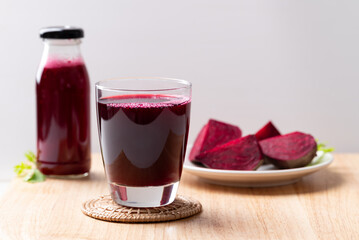 Fresh beetroot juice in glass and bottle on wooden board, Healthy drink