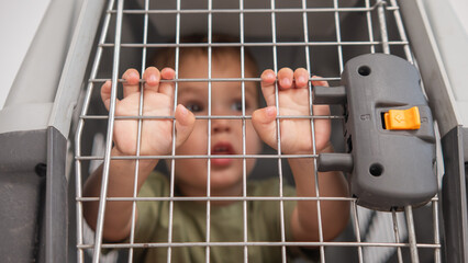A small child in a closed cage.