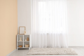 Shelf unit with frame and decor near light curtain in room