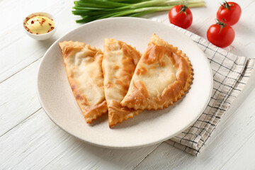 Plate with tasty chebureks on white wooden background