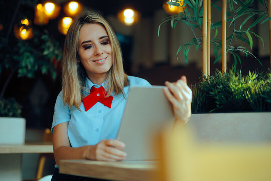 Restaurant Manager Holding a PC Tablet Working. Happy fast food worker looking at online customer orders 
 - Powered by Adobe