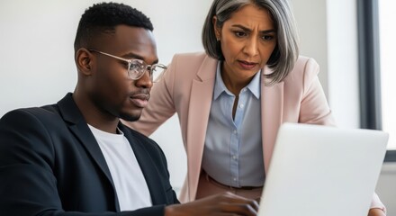 Photo of two business people collaborating on a laptop in the office