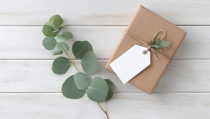 Wrapped gift with blank tag and eucalyptus leaves on wooden surface, creating serene atmosphere