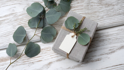 Elegant gift wrapped in linen with eucalyptus leaves and blank tag