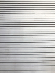 Fototapeta premium Minimalist horizontal metal shutter texture in silver color, perfect for industrial, architectural, or urban design backgrounds.