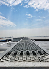 The Vertical shot of Solar rooftop walkway installation on clouds in the blue sky background.