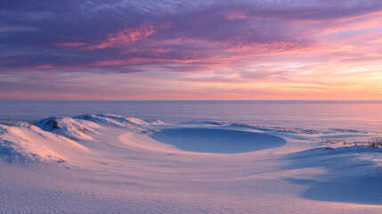 Serene winter landscape featuring snow covered dunes under colorful sunset sky