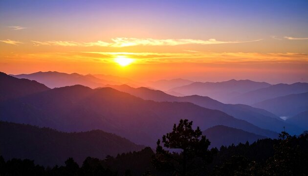 A vibrant sunset over a layered mountain range, casting a warm glow on the landscape.
