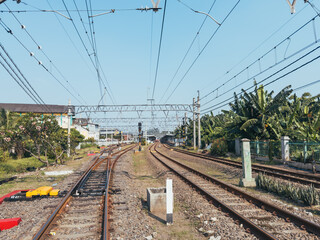 Obraz premium Clear Day at Longtian Railway Station in Indonesia: Tracks Stretching into the Distance Under a Blue Sky
