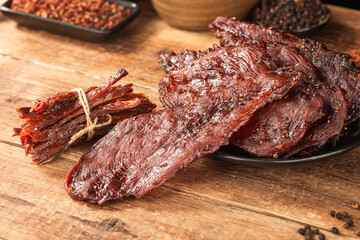 Dried chicken meat. Tasty jerky meat on cutting board.