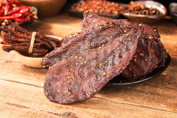 Dried chicken meat. Tasty jerky meat on cutting board.