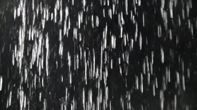 Seamlessly looped close-up animation of falling rain with realistic raindrops, vertical rainfall resembling a rain wall. Real rainstorm VFX insert style, dark black background, 4K resolution, high det
