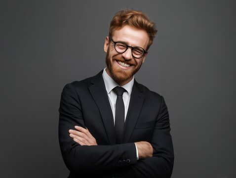 Smiling ginger man in formal suit and eyewear with crossed arms pose on dark background, concept for executive portrait, confident presentation and corporate leadership visuals