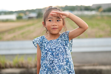 A little Asian girl salutes like a police officer and a soldier. Pretend play