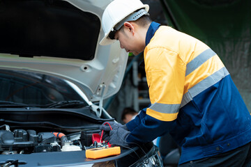 Asian male automotive technician who inspects, repairs, and maintains all vehicle systems,ensuring...