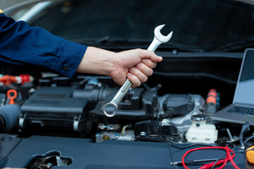 Asian male automotive technician who inspects, repairs, and maintains all vehicle systems,ensuring...