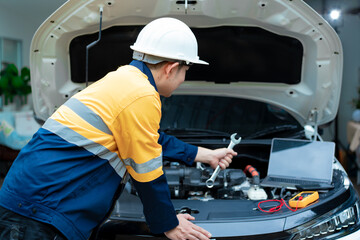 Asian male automotive technician who inspects, repairs, and maintains all vehicle systems,ensuring...
