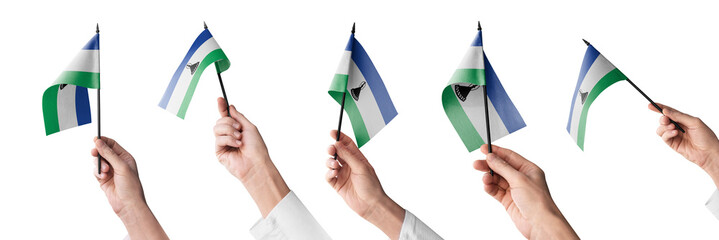 The Lesotho flag in hand in different angles on a white background