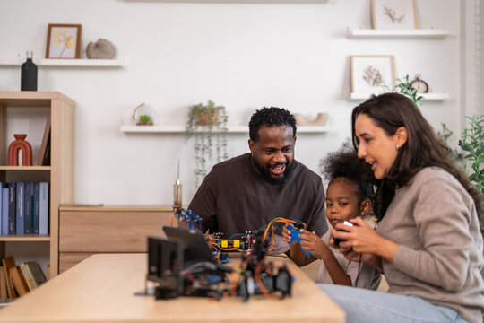 African love family, father mother and daughter learning STEM education, science experiment, robotics toy, technology and innovation interactive learning, creativity and development at home - Powered by Adobe