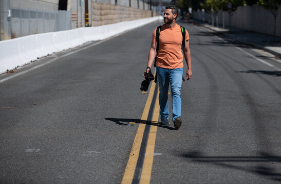Man photographer tourist walk on street with a large professional camera. Portrait of photographer with camera outdoor. Tourist photographer.