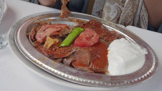 Delicious iskender kebap served with fresh vegetables and sauce
