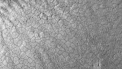 Cracked mud texture on dried riverbed in black and white