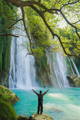 Adventurous spirit at Cikaso Waterfall, Indonesia. Forest trail and cliffside views create...