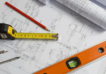 Architectural plans and drafting tools on a desk for a new construction project. Workspace with blueprints, tape measure, and level.