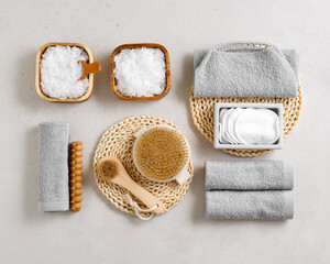 Plakat Natural spa, wellness, bath accessories as minimal flat lay pattern, sea salt flakes in wooden bowls, soft gray towels, brush, reusable cotton pads, grey conctrete background, top view neutral colors