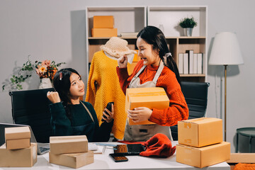 Portrait of Starting small businesses SME owners, two Asian woman check online orders Selling...