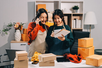 Portrait of Starting small businesses SME owners, two Asian woman check online orders Selling...