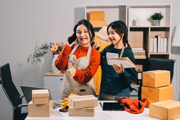 Portrait of Starting small businesses SME owners, two Asian woman check online orders Selling...