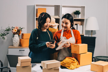 Portrait of Starting small businesses SME owners, two Asian woman check online orders Selling...