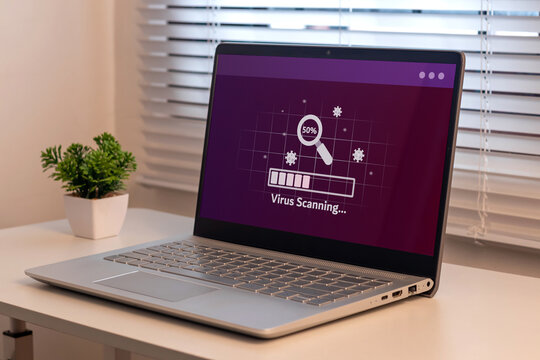 A laptop on the table with virus scanning process. Anti virus and bug protection technology concept. - Powered by Adobe