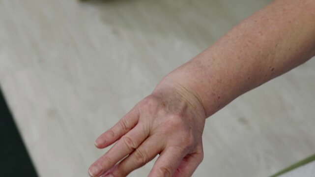 Close up of an elderly woman's hands performing contracture and shortening of tendons various stretching and flexing exercises, likely part of physiotherapy routine to improve mobility and strength